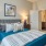 a bed with a blue and white striped blanket and pillows in a room